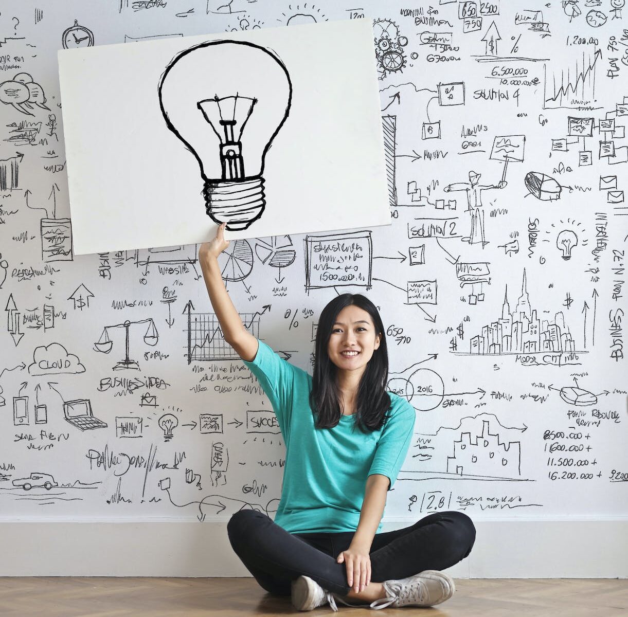 woman draw a light bulb in white board