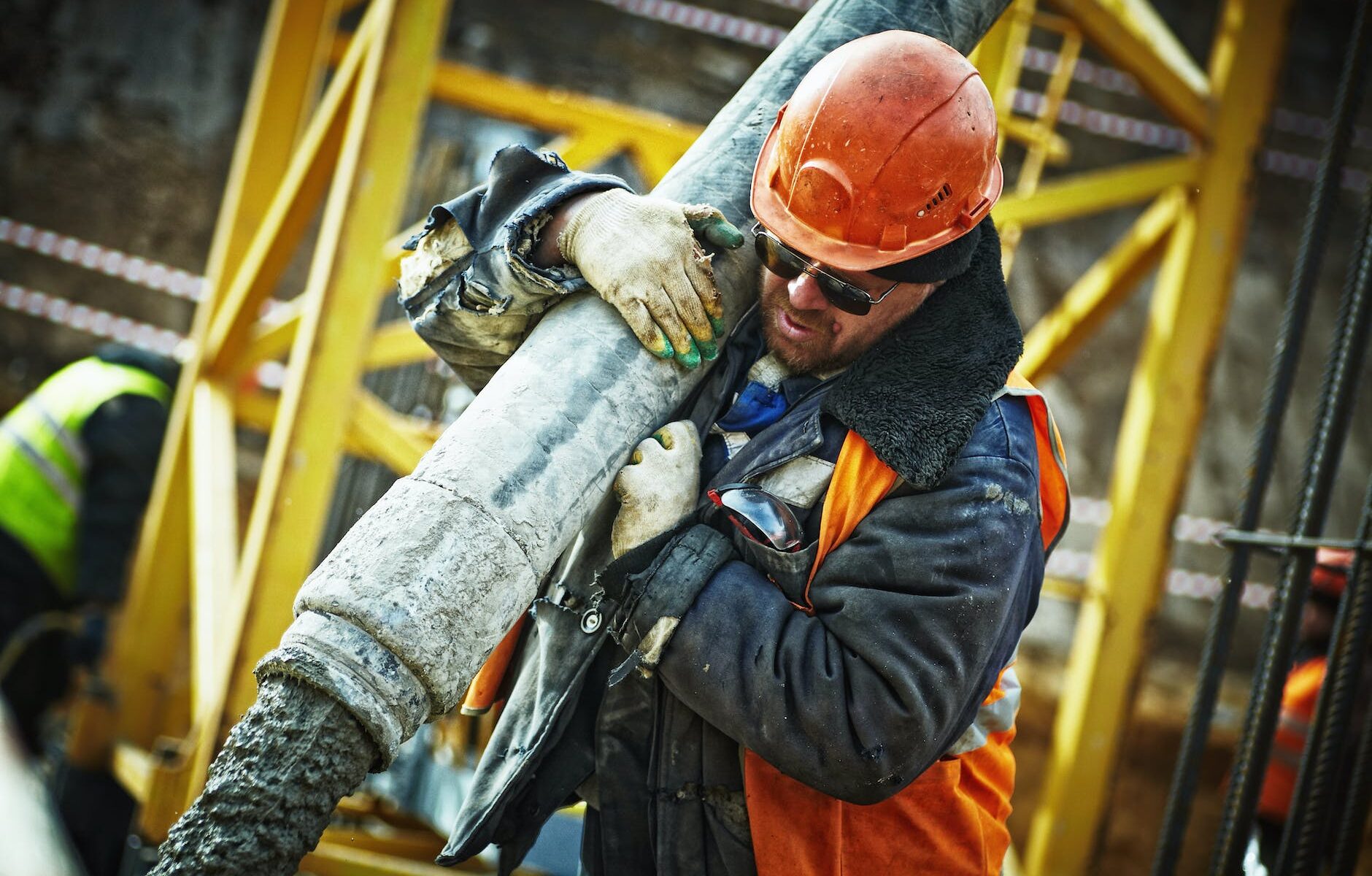 man carrying gray pipe